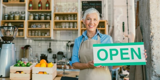 cafe lady holding open board in kitchen