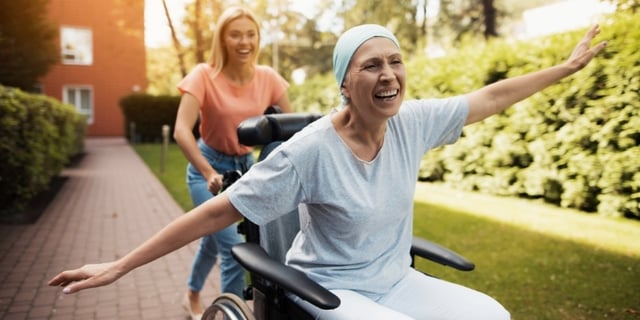 end-of-life senior on wheel char feeling joyful with volunteer