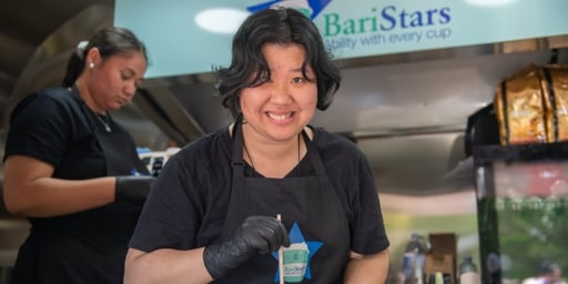female disability barista making coffee in baristars coffee cart