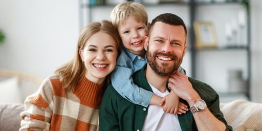 happy parents with kid on sofa