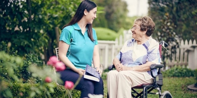 home care specialist enjoying time with senior client in garden