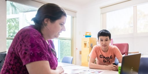 kid looking at laptop in a occupational therapy session
