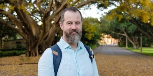 male with beard with trees in background