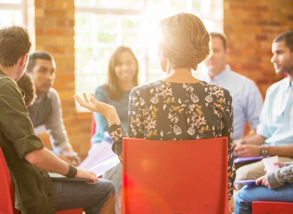 woman-speaking-in-group-therapy-session