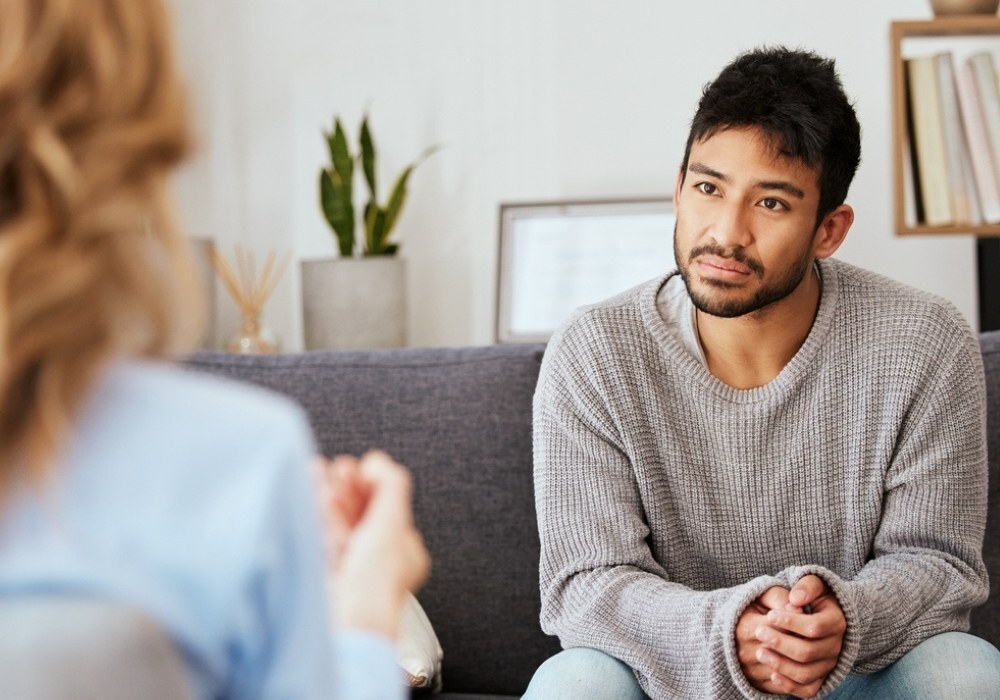 adult man on couch talking to a counsellor