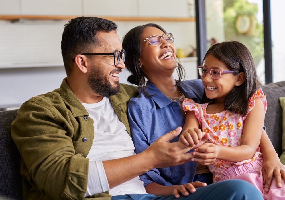 happy parents with daughter sitting in lap