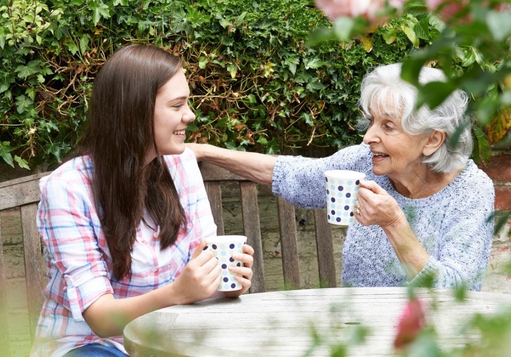 home care specialist sipping coffee with senior woman