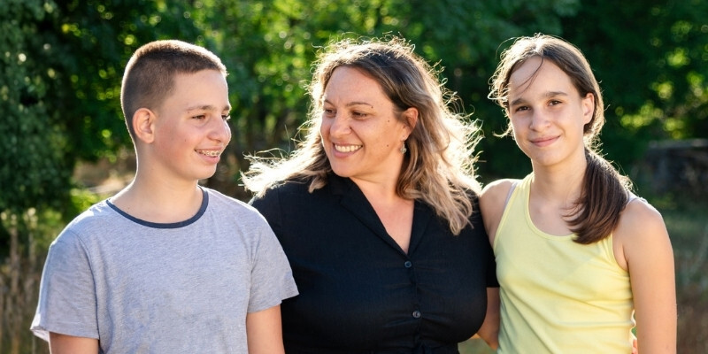 mother with young boy and girl in park