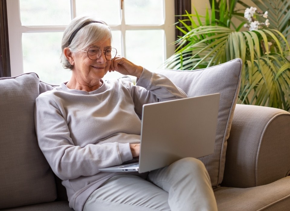 senior on laptop connected digitally to the world