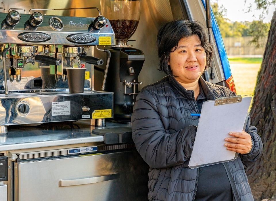 young BariStar with coffee machine holding writing board